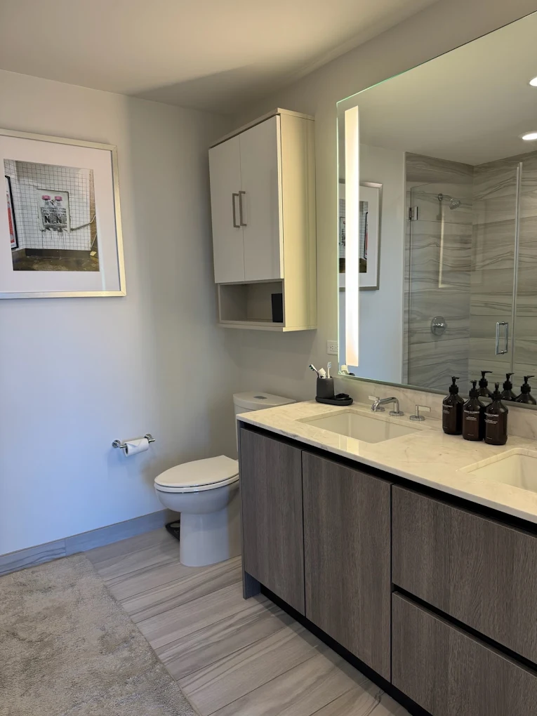 Grey bathroom vanity with lit mirror